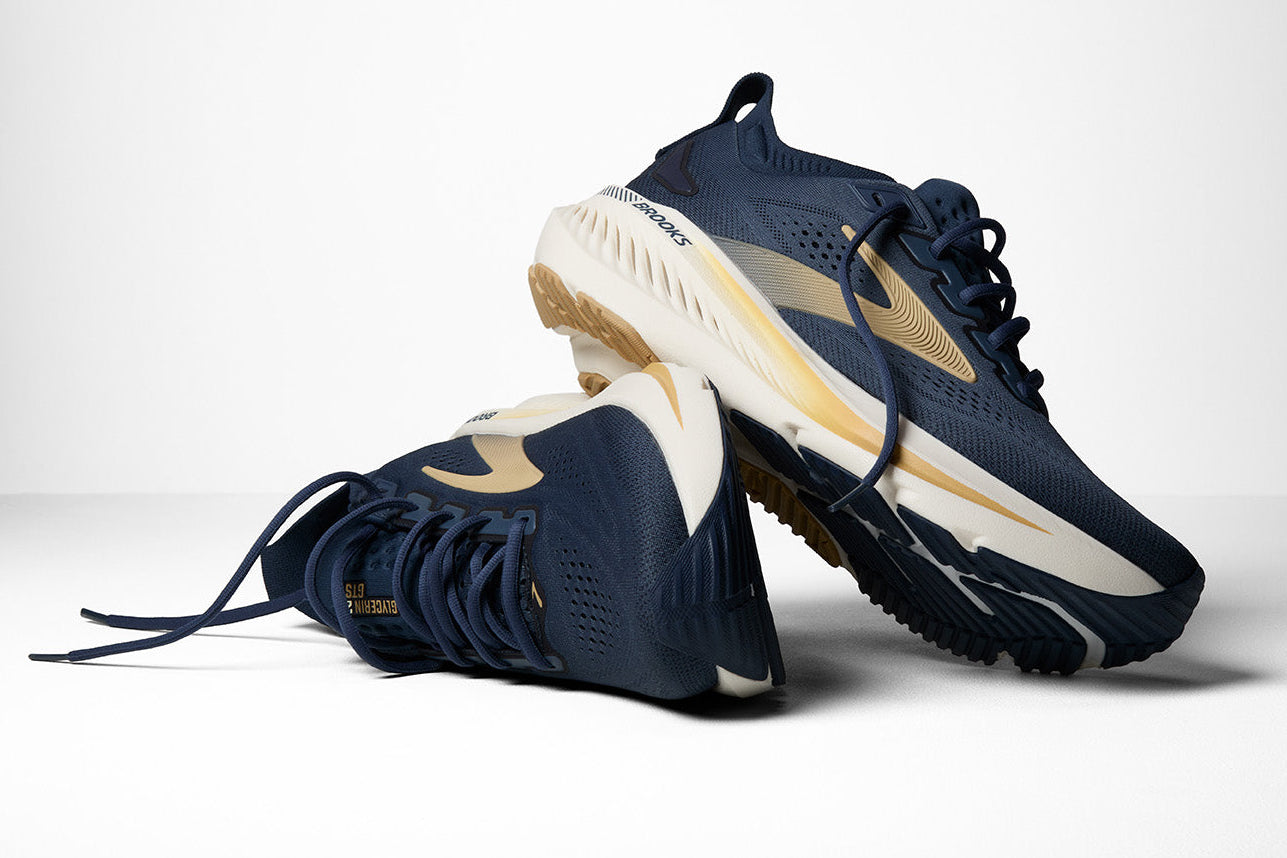 Navy and gold running shoes on a white background