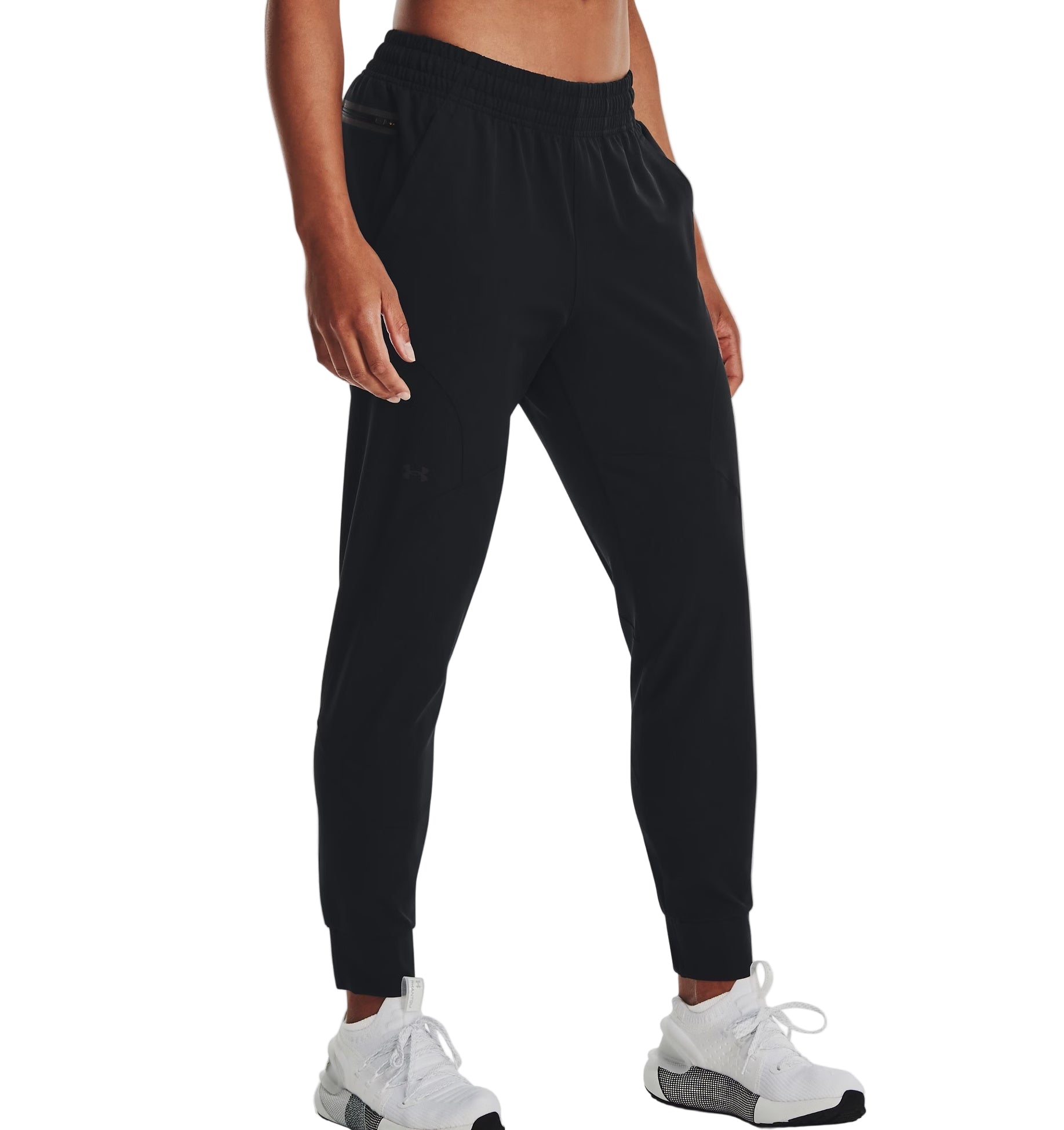 Person wearing black jogger pants and white sneakers on a white background