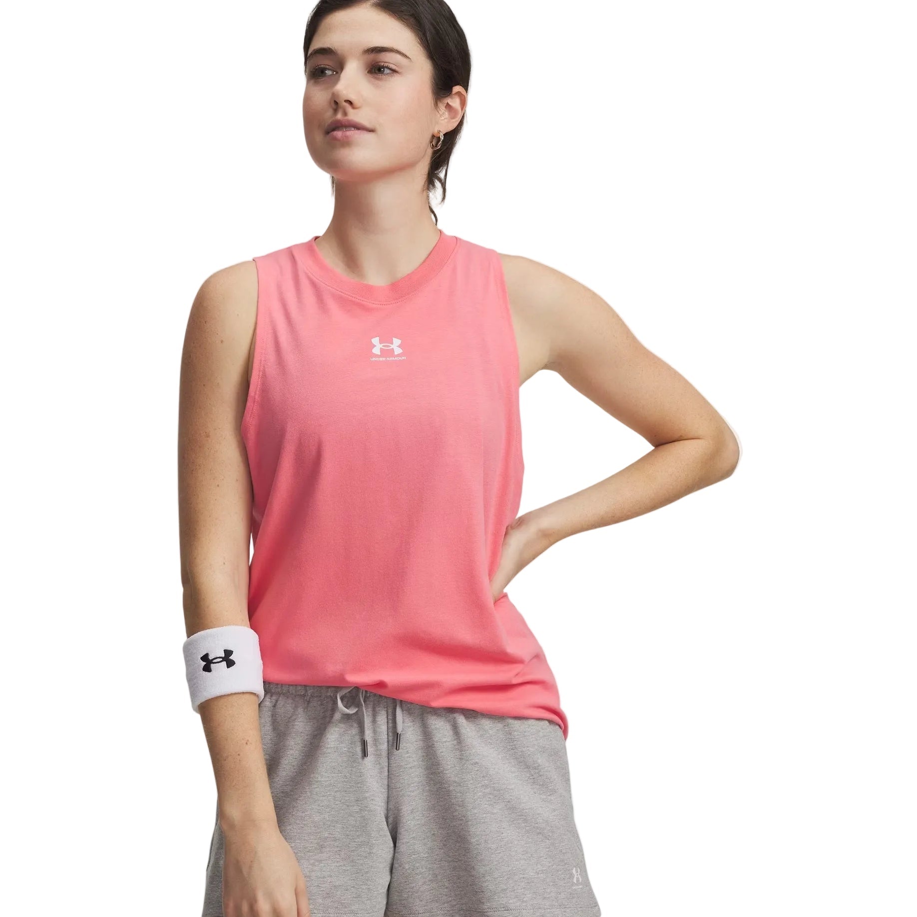 Woman wearing a pink Under Armour tank top and gray shorts on a white background