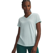 Woman wearing a light blue athletic shirt and green leggings on a white background