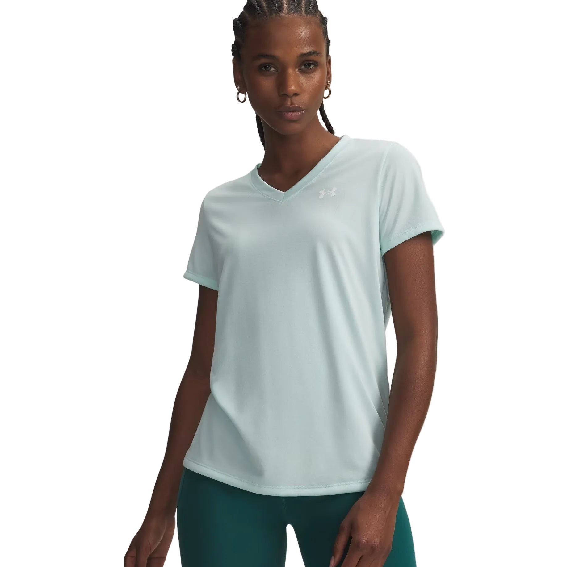 Woman wearing a light blue athletic shirt and green leggings on a white background
