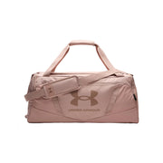 A dusty pink Under Armour duffel bag with a matching adjustable shoulder strap and a tonal logo on the front, set against a plain white background.