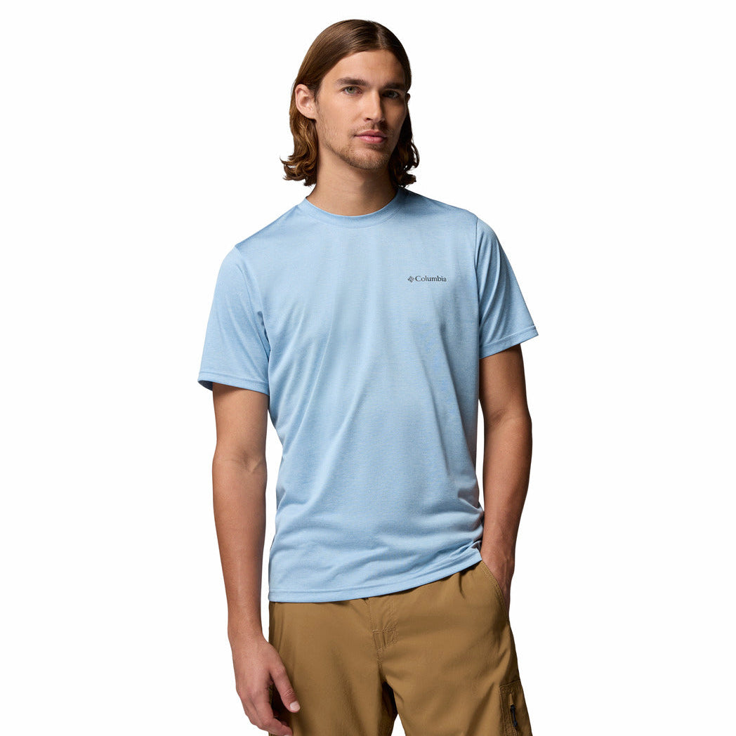 Person wearing a light blue t-shirt with a brand logo on a white background