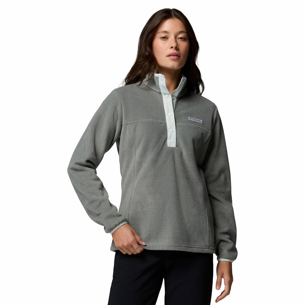 A woman modeling a heather gray quarter-zip fleece pullover with a light gray collar and zipper trim, featuring a small embroidered logo on the left chest.