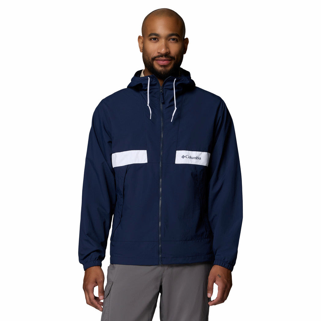 Man wearing a navy blue jacket with white accents on a white background