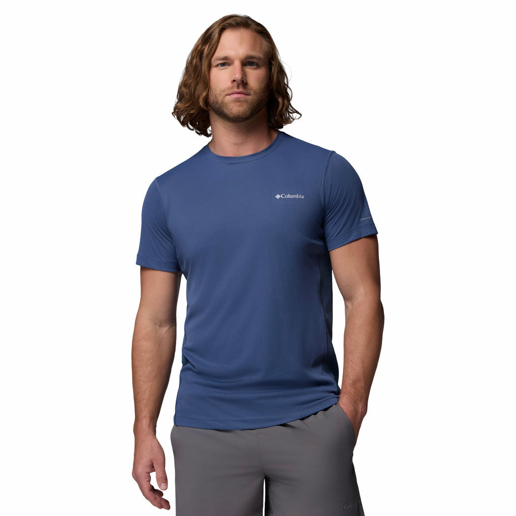 Man wearing a blue t-shirt with a brand logo on a white background