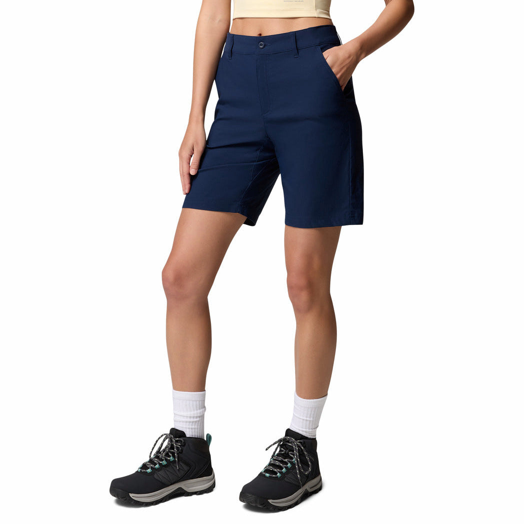 Person wearing navy shorts and hiking boots on a white background