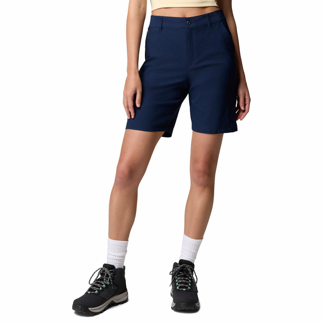 Person wearing navy shorts and hiking boots on a white background