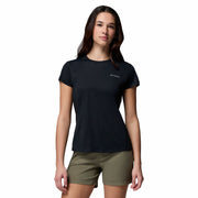 Woman wearing a black t-shirt with a logo and green shorts on a white background