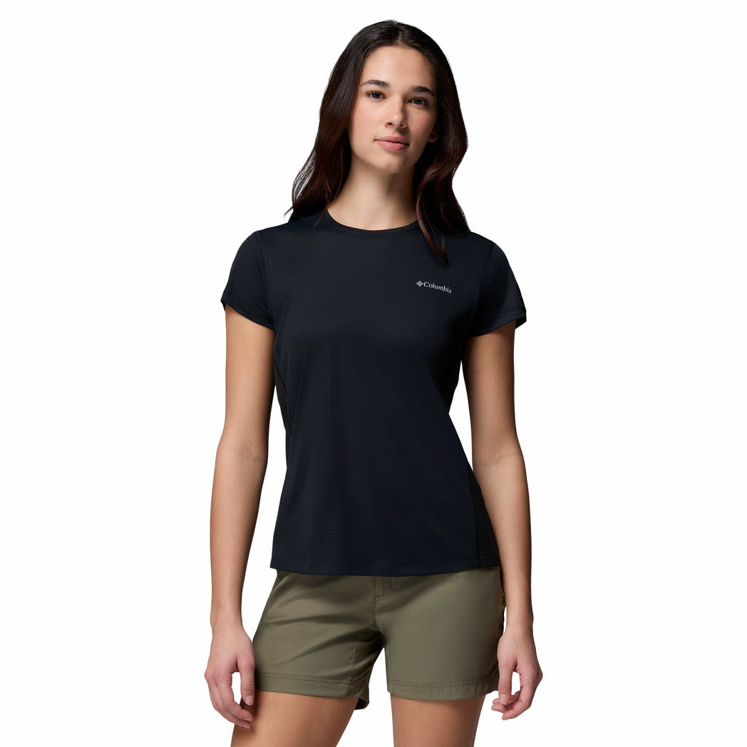 Woman wearing a black t-shirt with a logo and green shorts on a white background