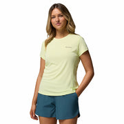 Woman wearing a light green t-shirt and teal shorts on a white background