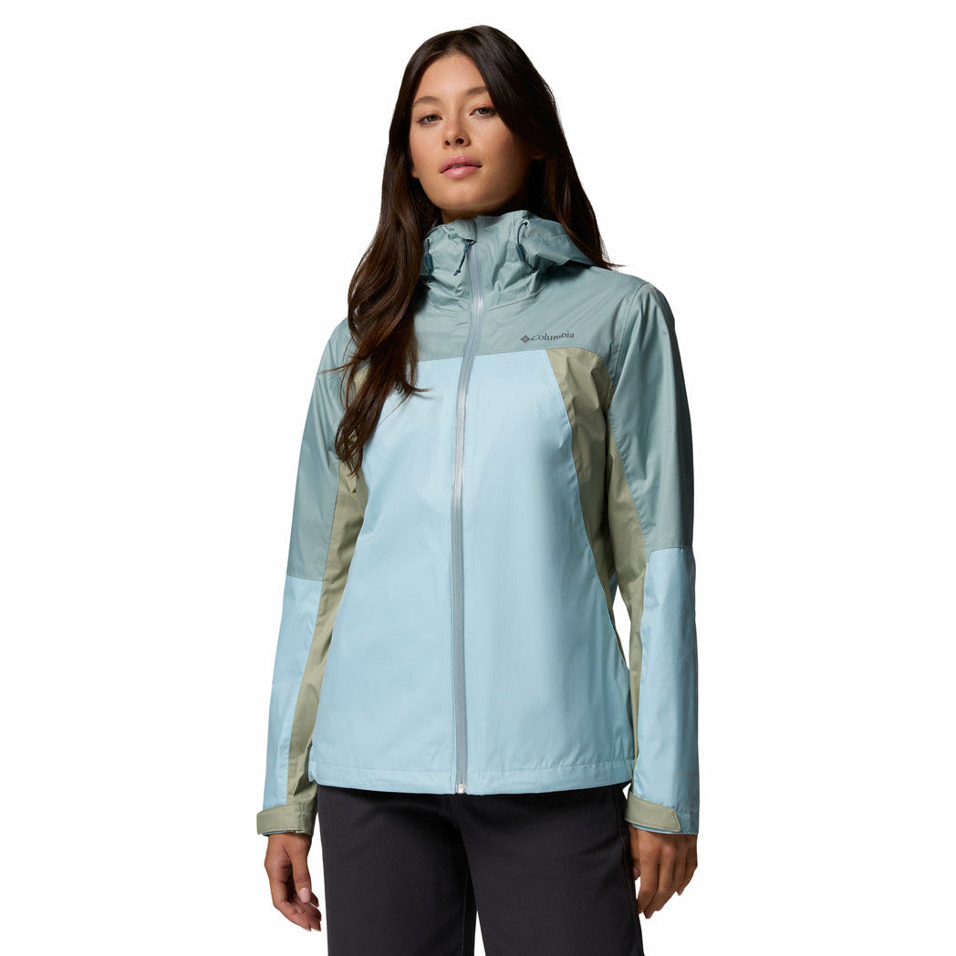 Woman wearing a light blue and green jacket on a white background