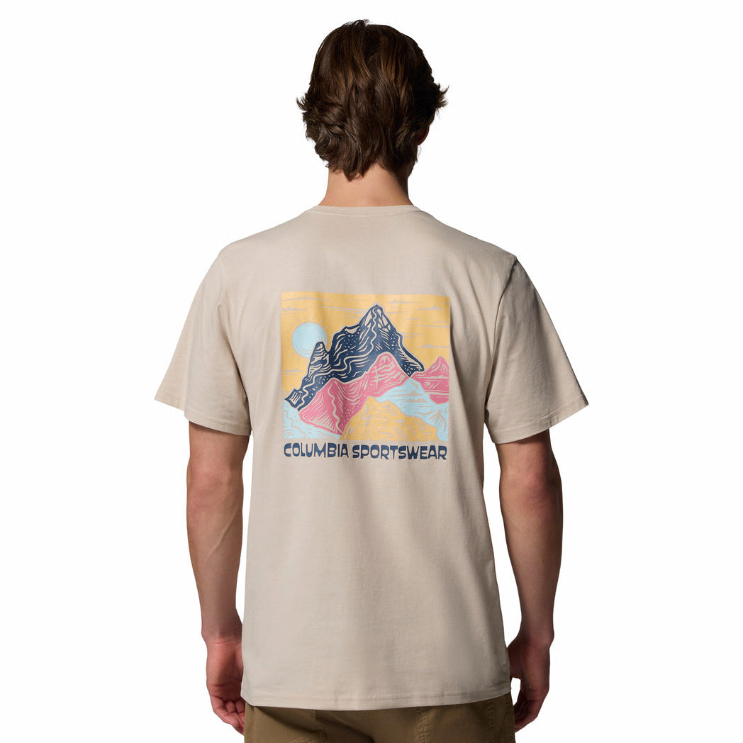 Person wearing a beige t-shirt with a mountain graphic and Columbia Sportswear logo on the back.