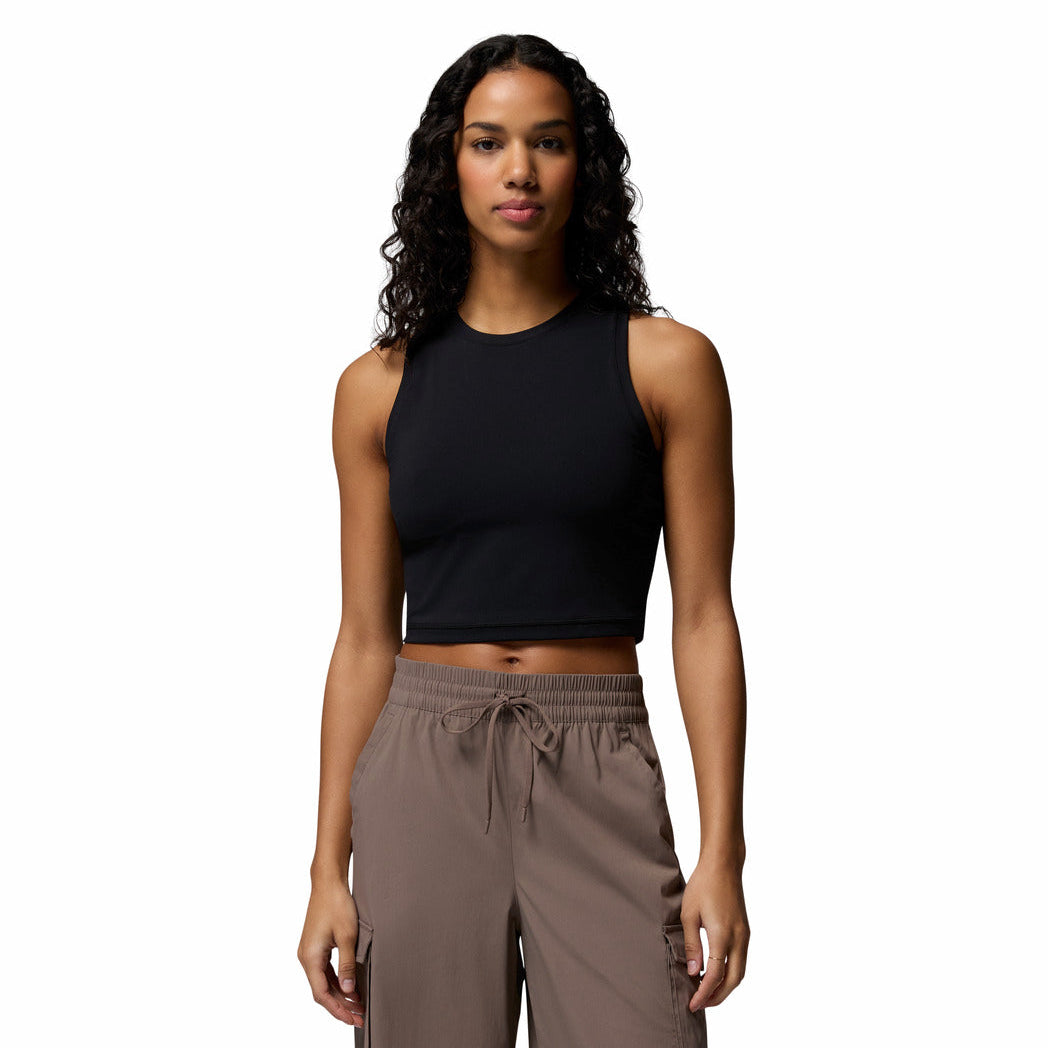 Woman wearing a black sleeveless top and brown pants on a white background