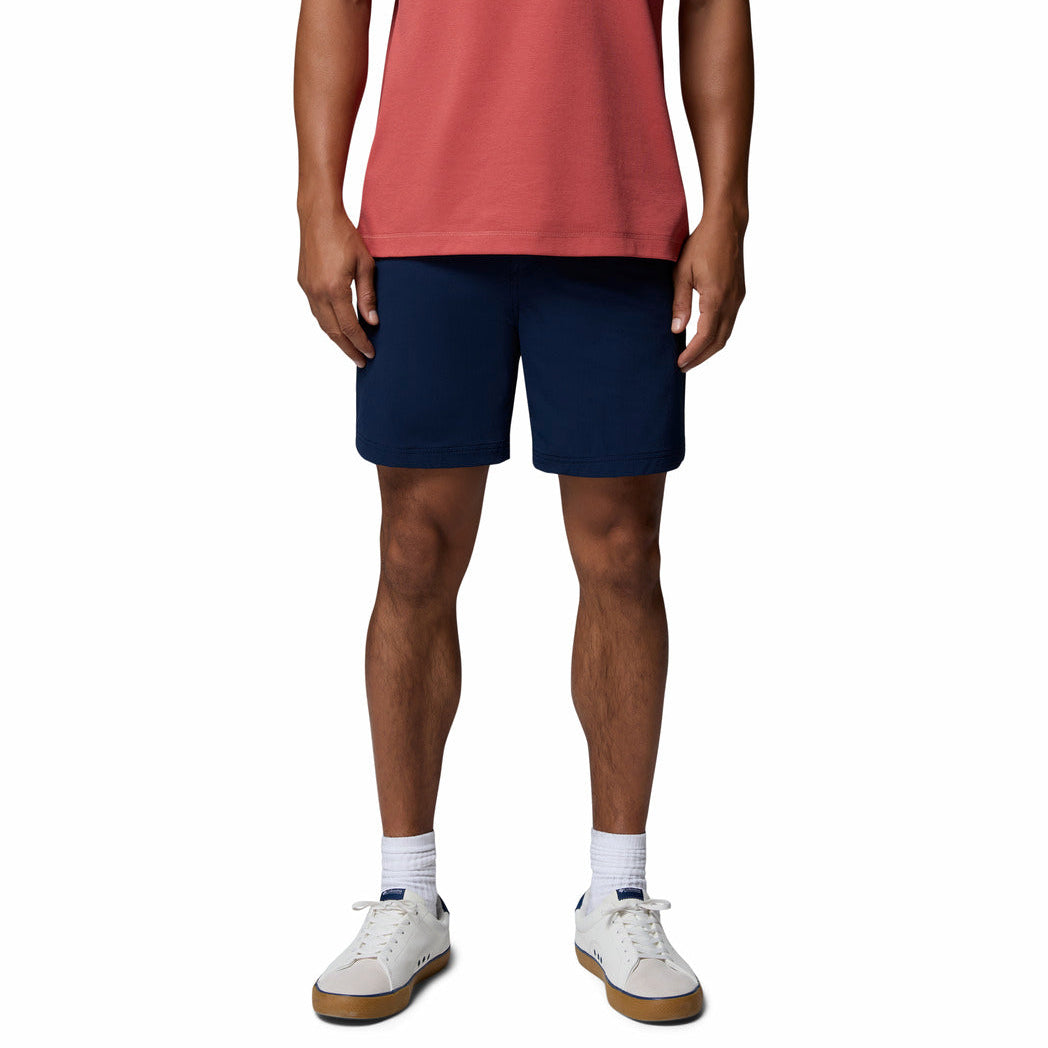 Person wearing navy shorts and a red shirt on a white background