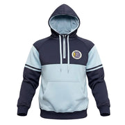 A colorblock pullover hoodie with a navy blue hood, shoulders, and cuffs, and a light blue body and hood lining. It features white drawstrings, a front kangaroo pocket, and a circular crest patch on the left chest, displayed on a clean white background.