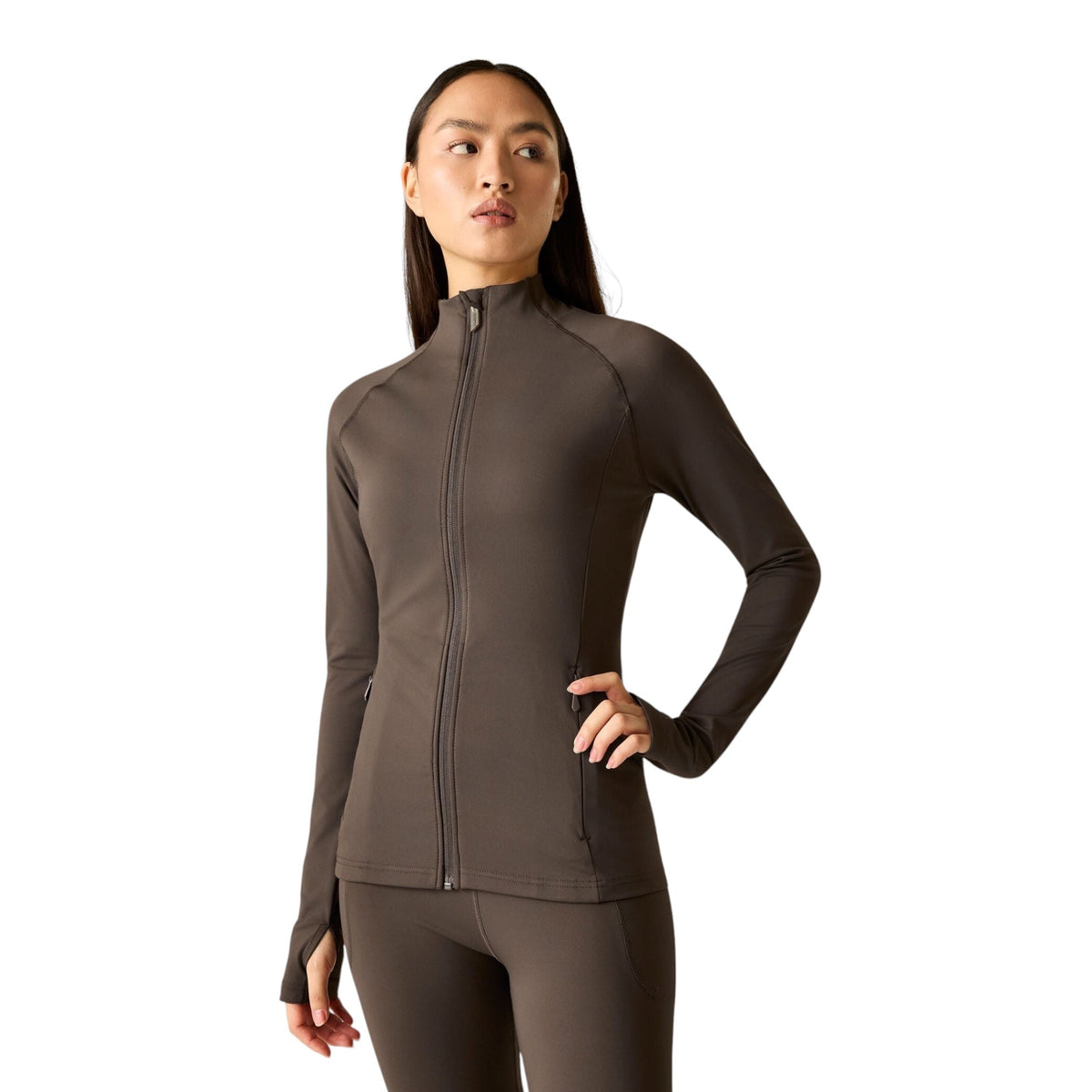 A woman modeling a dark brown long-sleeve athletic zip-up jacket and matching leggings against a solid white background.