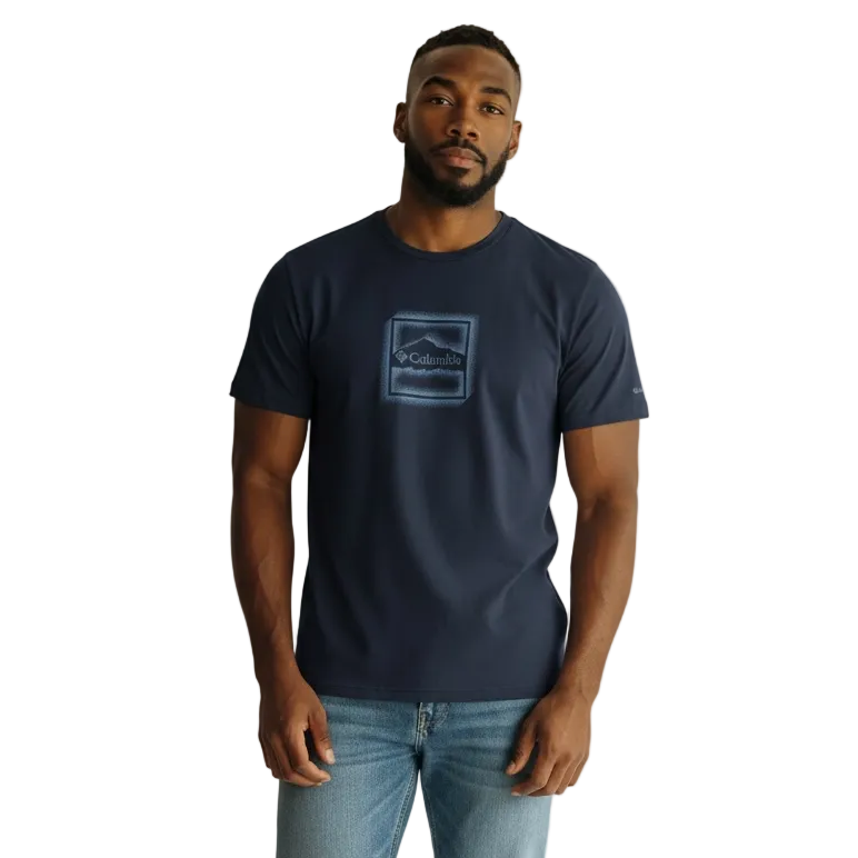 Man wearing a navy t-shirt with a logo and light blue jeans on a white background