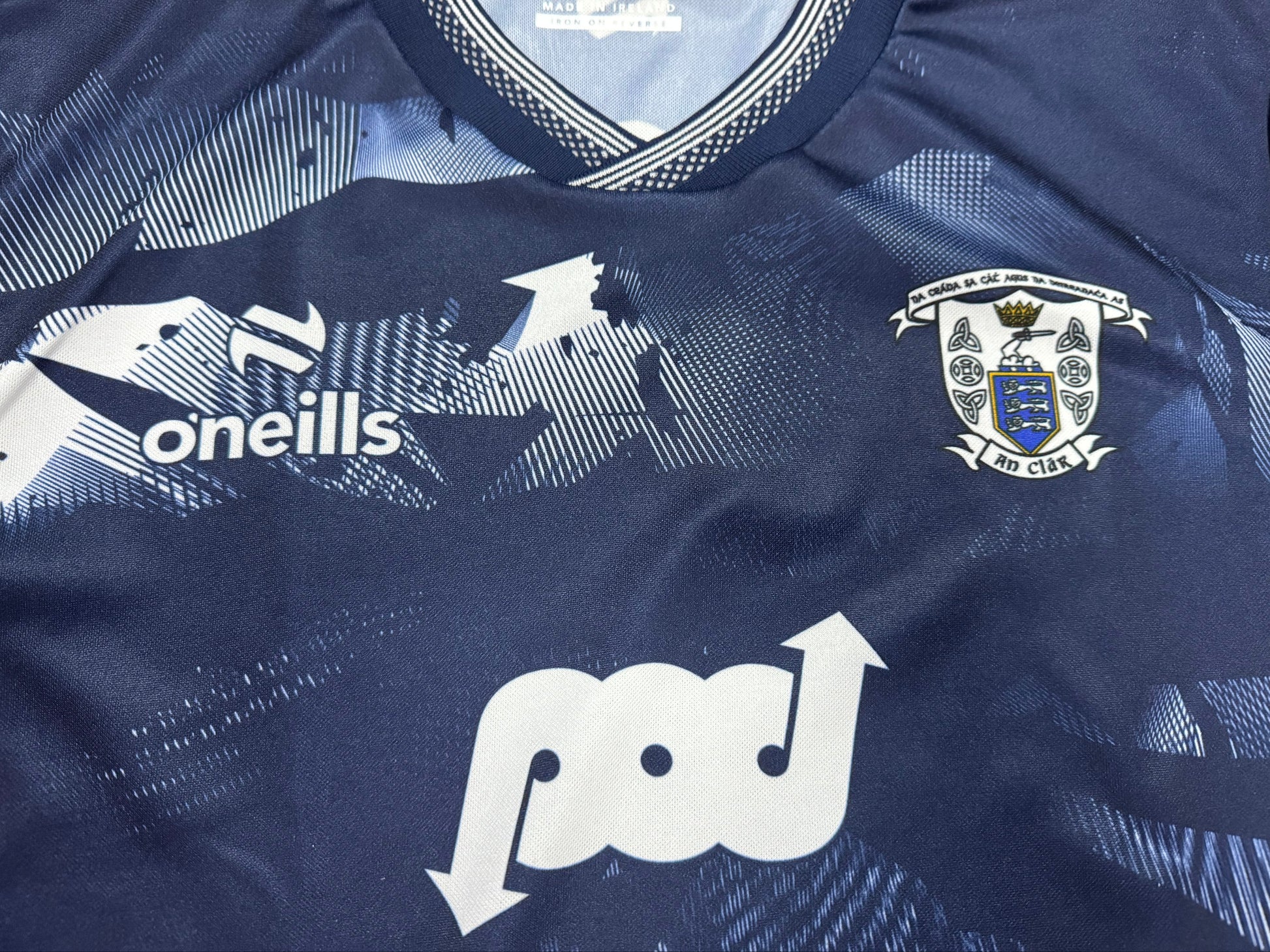 Navy sports jersey with logos on a flat surface