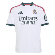 A white Real Madrid soccer jersey with dark green trim, featuring the Adidas logo, Real Madrid crest, Emirates Fly Better sponsor text, and a Real Madrid 'h' patch on the sleeve.