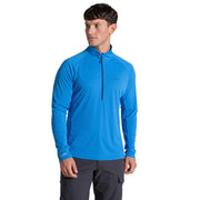 Man wearing a blue long-sleeve athletic shirt with a zipper on a beige background