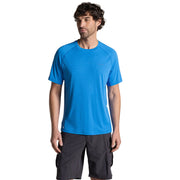Man wearing a blue athletic shirt and black shorts on a beige background