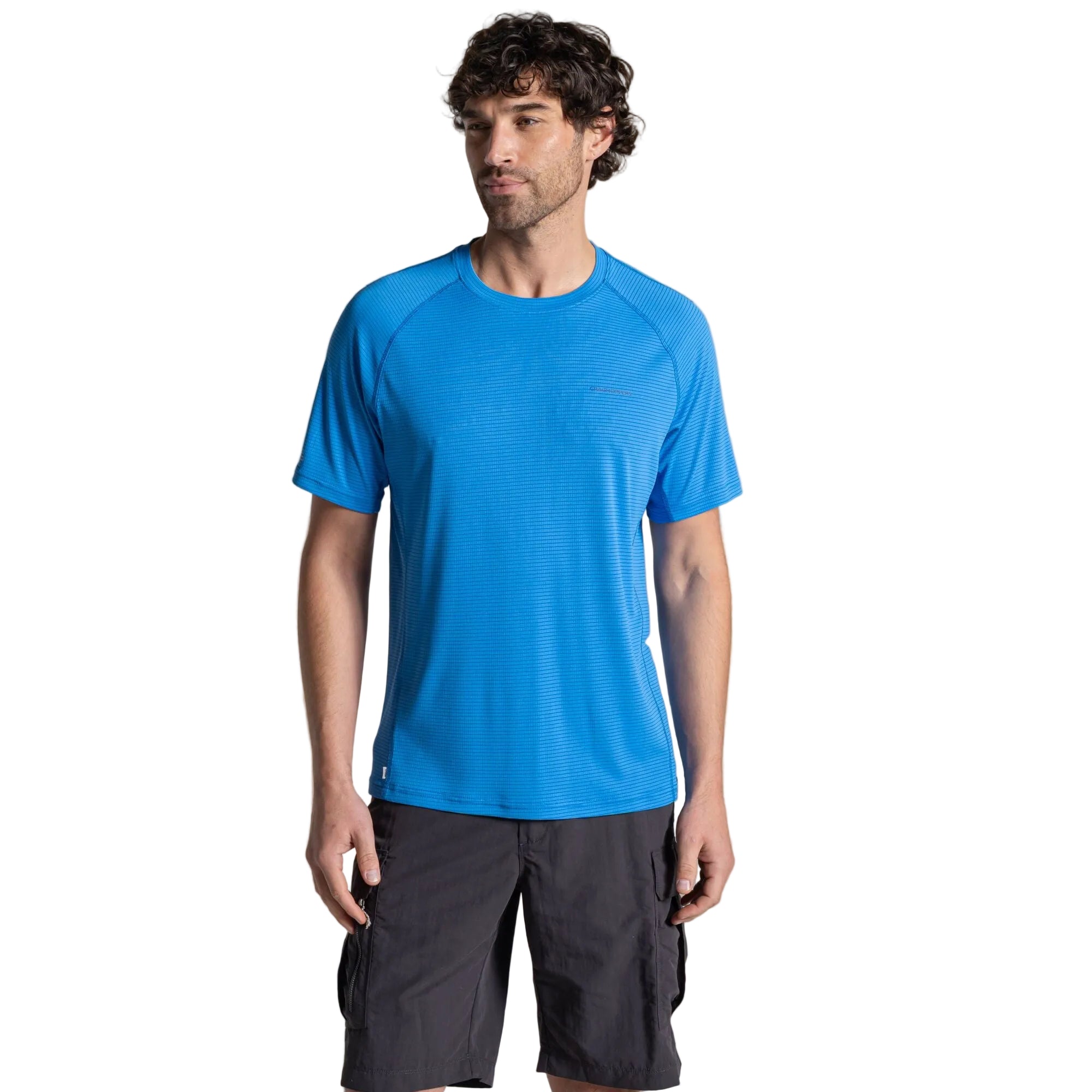 Man wearing a blue athletic shirt and black shorts on a beige background