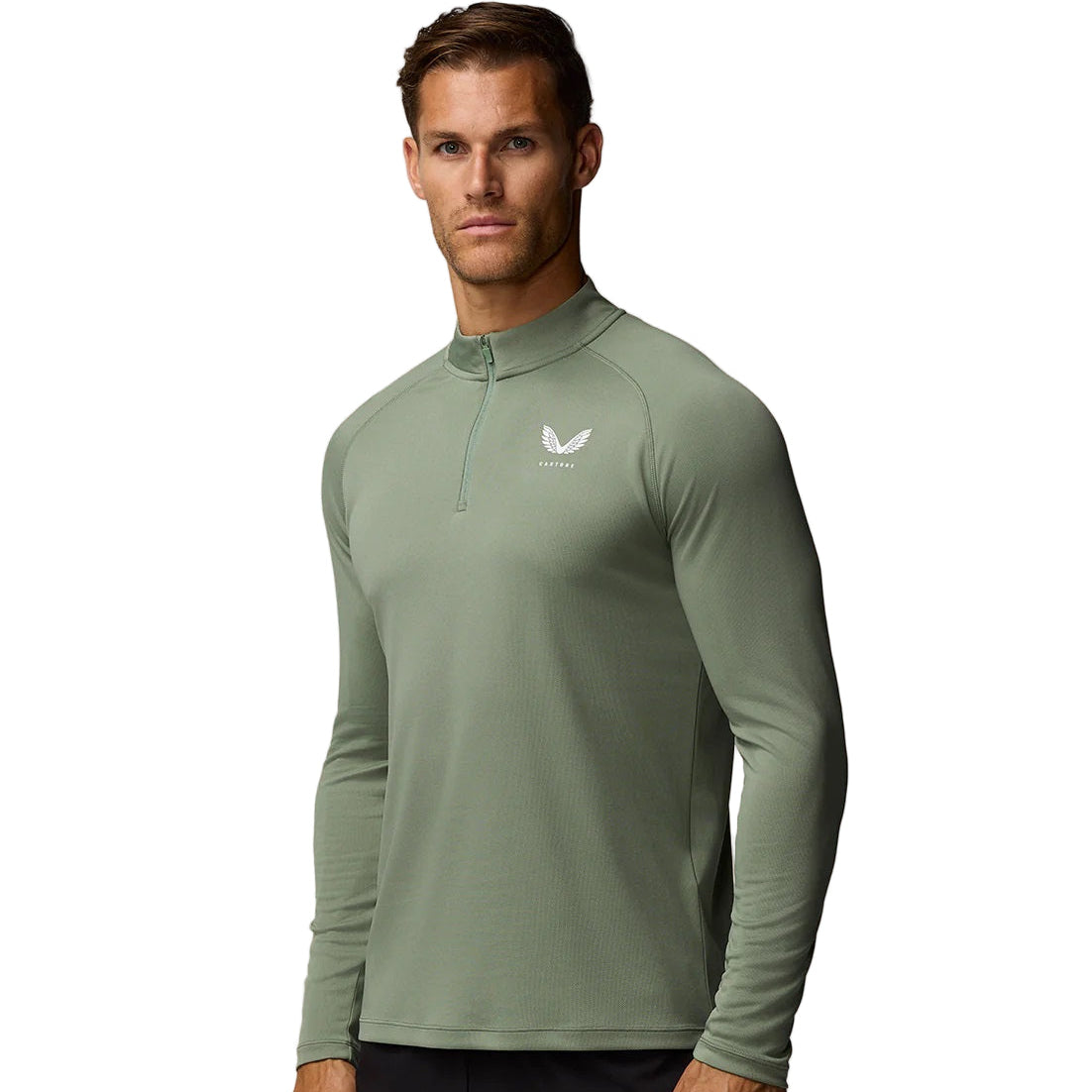 Man wearing a green long-sleeve athletic shirt with a logo on a beige background