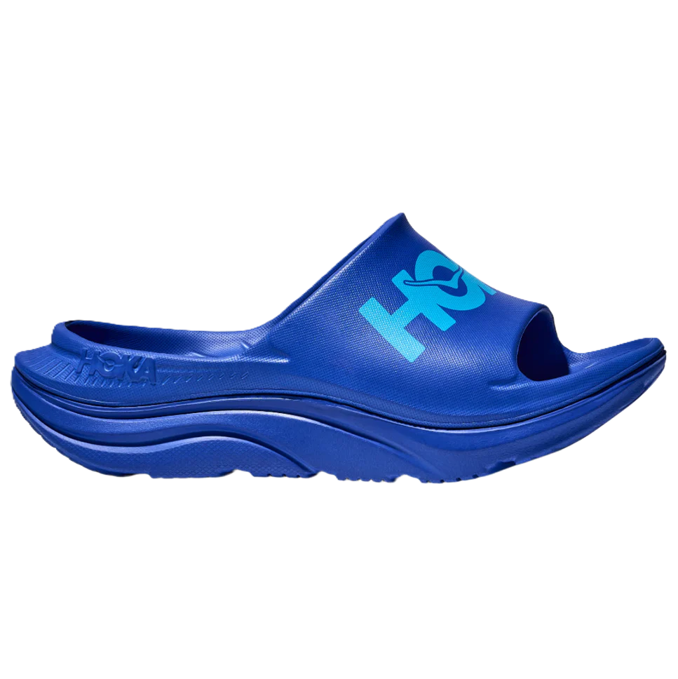 Blue slide sandal with 'HOKA' branding on a white background