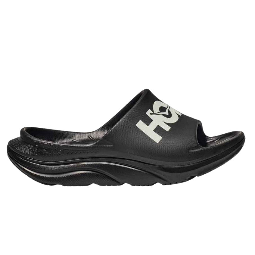 Black slide sandal with 'HOKA' branding on a white background