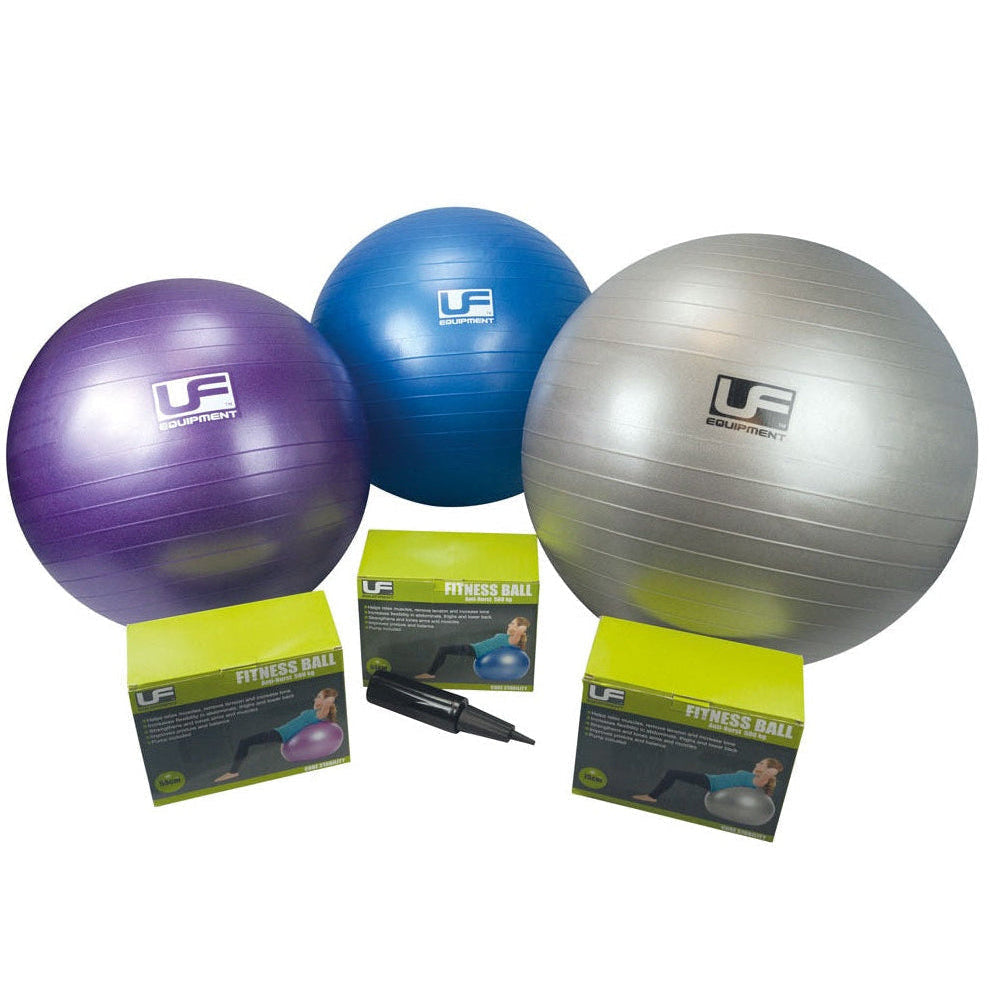 Three exercise balls (purple, blue, silver) with packaging and a pump on a white background.